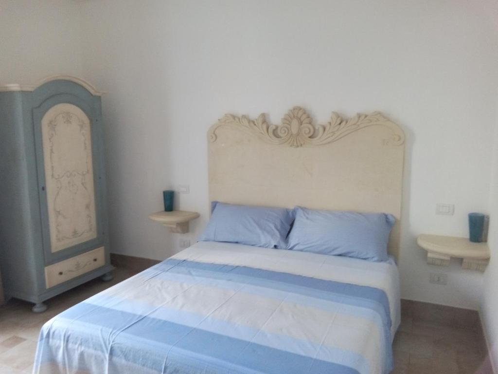 una camera da letto con un grande letto con cuscini blu di "Pozzo della Corte" - un Raffinato Nido d'Amore Salentino a Sannicola