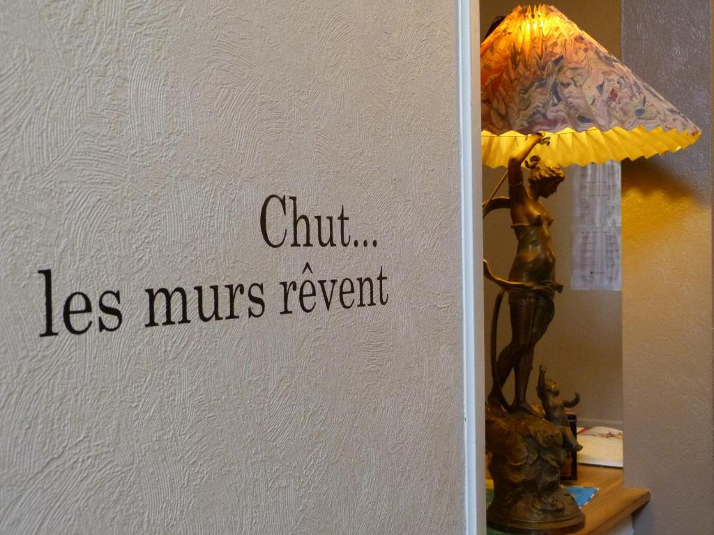 una lámpara sobre una mesa con un cartel en la pared en Hôtel Le Bretagne en Vannes