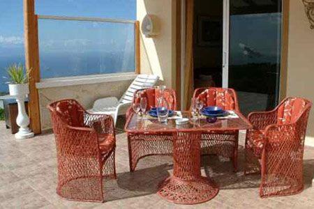 einen Rattantisch und Stühle mit einem Tisch, einem Tisch und Stühlen in der Unterkunft Suite Mariposa Finca Montimar in Chio