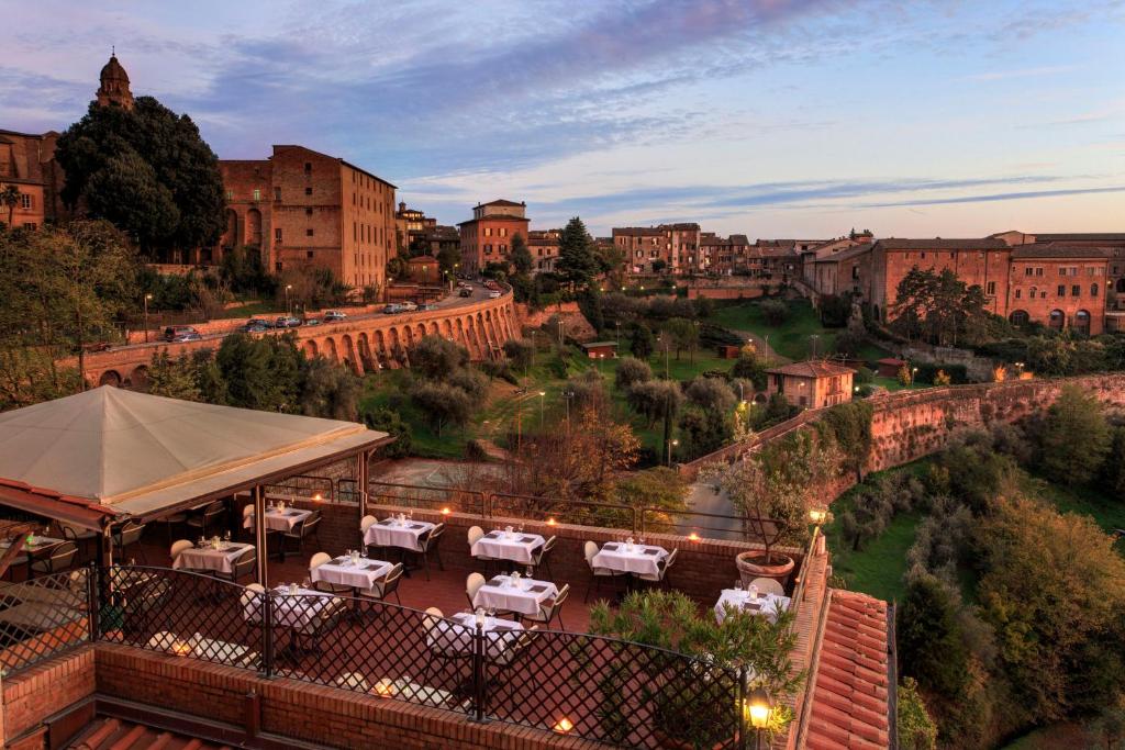 uma vista para uma cidade com mesas e edifícios em Hotel Athena em Siena
