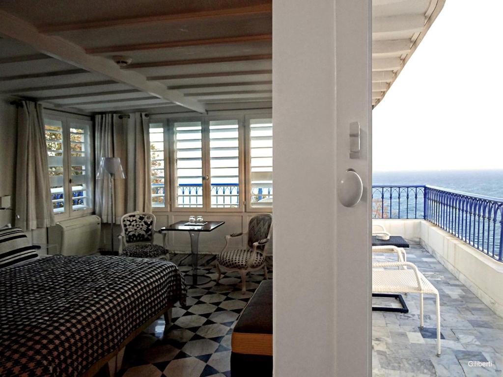 a bedroom with a bed and a balcony with the ocean at La Villa Bleue-Sidi Bou Said in Sidi Bou Saïd