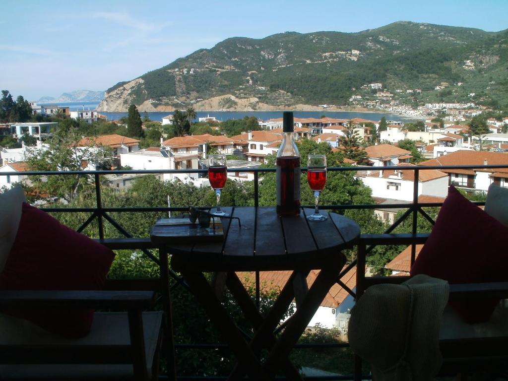 una mesa con 2 copas de vino en el balcón en Albatros, en Skopelos Town