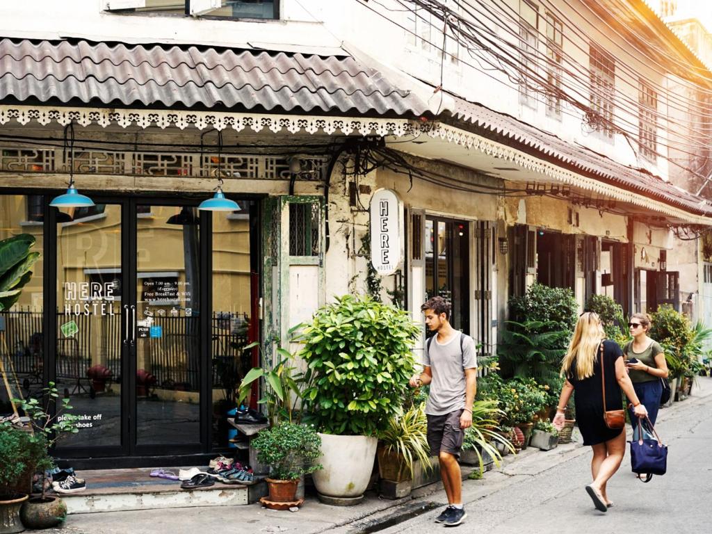 een groep mensen die op straat lopen bij Here Hostel Bangkok in Bangkok