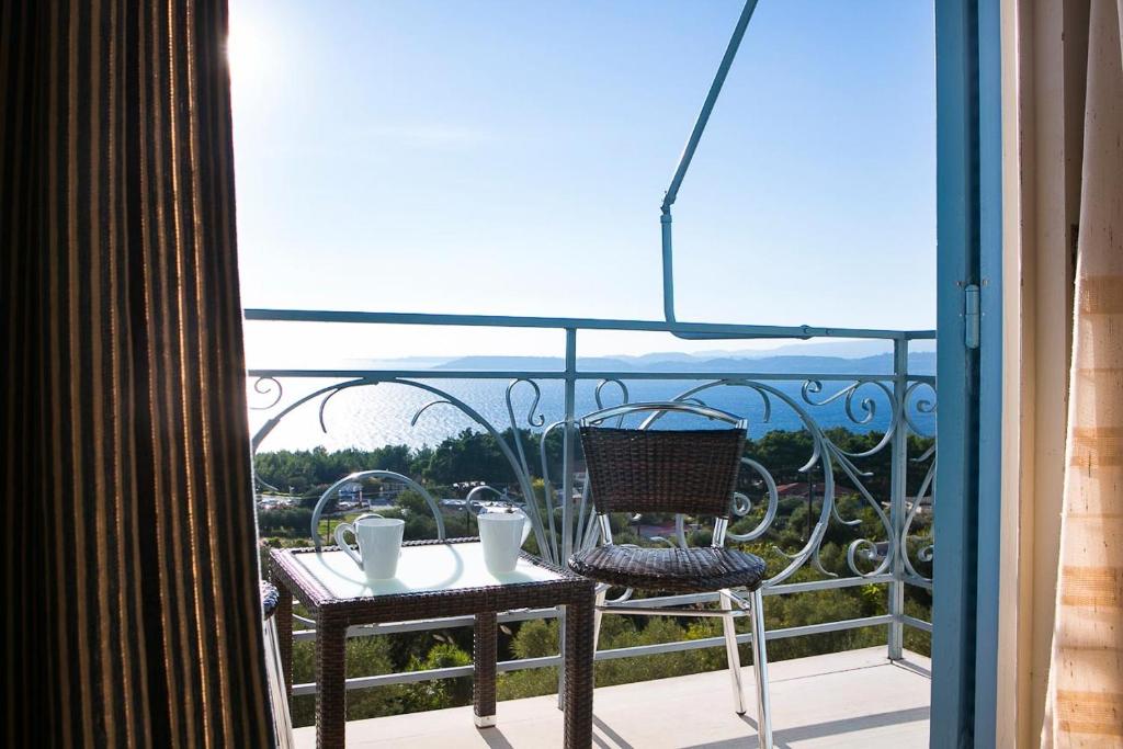 uma varanda com uma mesa e cadeiras e uma vista em Irini Apartment em Lassi