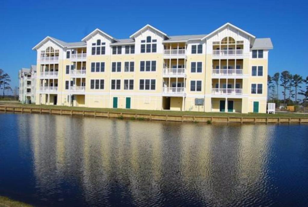 a large white building next to a body of water at Hamilton Cay at Bermuda Bay by Kees Vacations in Kill Devil Hills