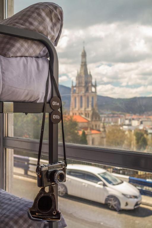 a camera sitting on a chair in front of a window at All Iron Hostel in Bilbao