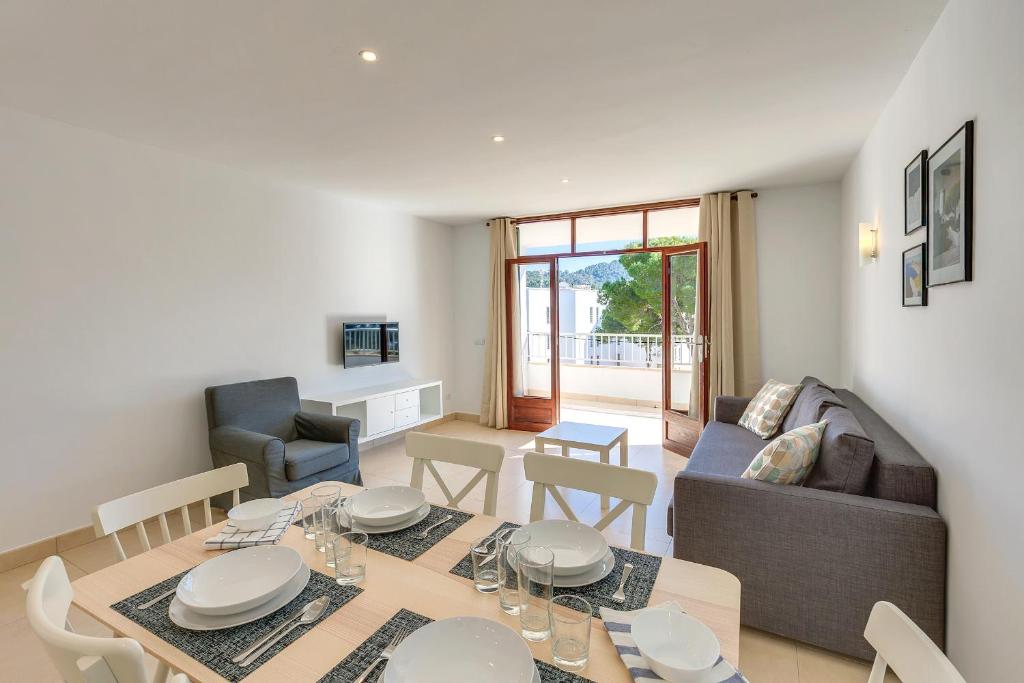 a dining room and living room with a table and chairs at Bagari Apartments Camp de Mar in Camp de Mar