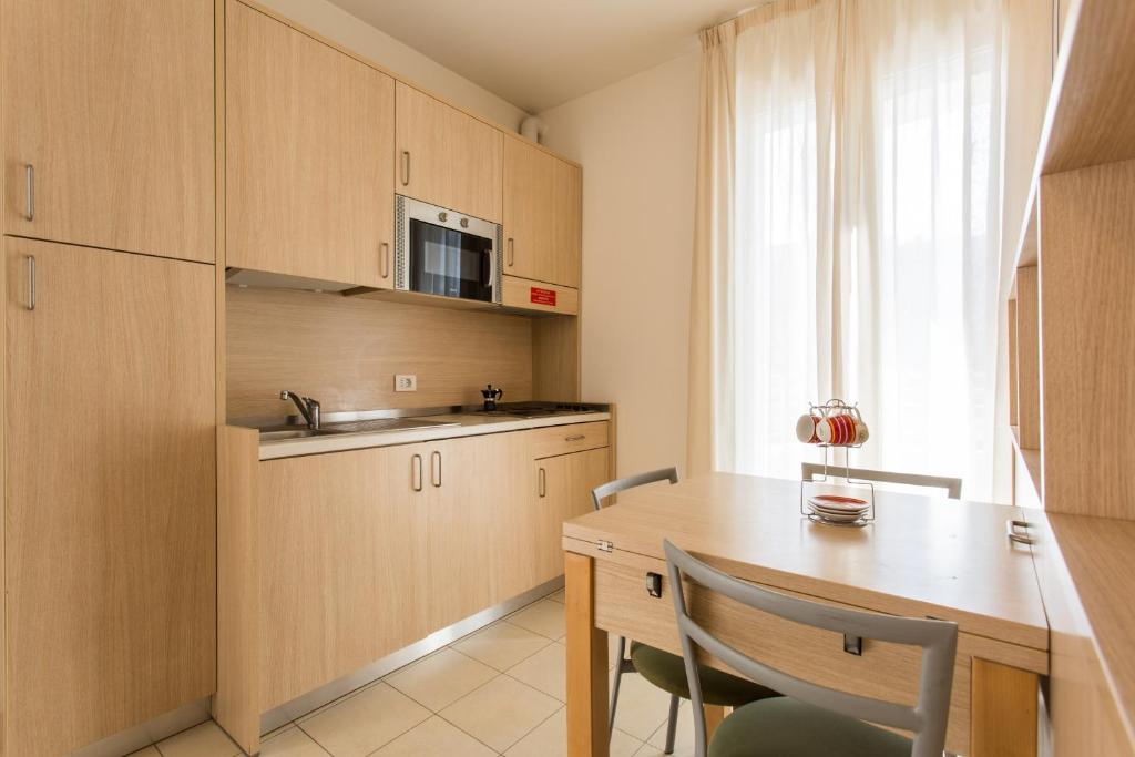 a kitchen with wooden cabinets and a wooden table at Wally Residence in Rimini
