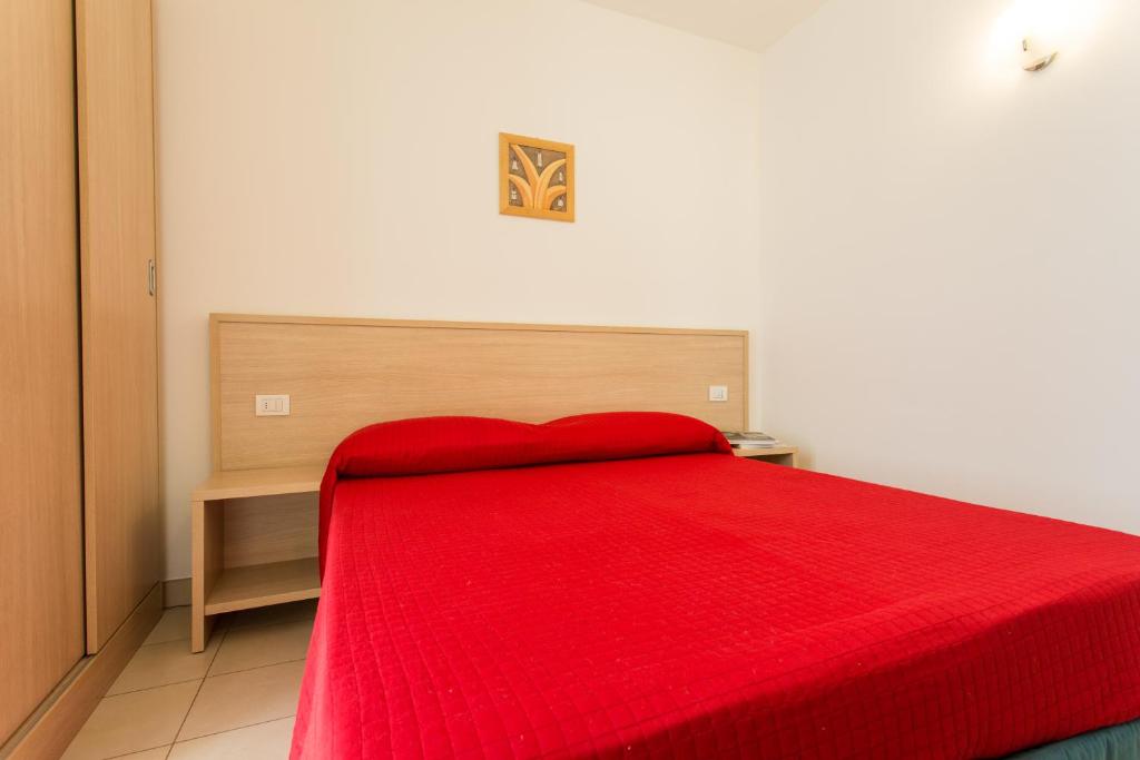 a bedroom with a red bed with a red blanket at Wally Residence in Rimini