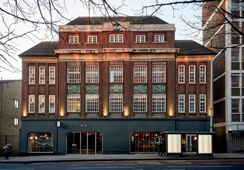 een groot bakstenen gebouw met veel ramen bij Green Rooms in Londen