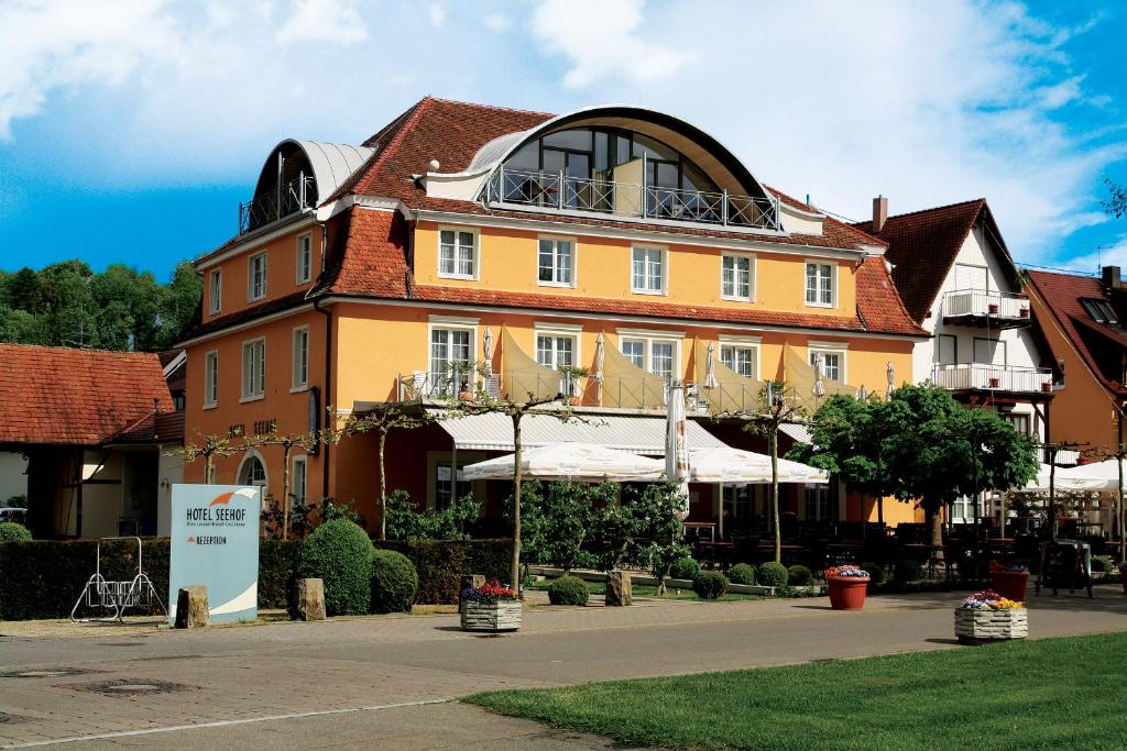 un grand bâtiment orange avec un haut rond dans l'établissement Hotel Seehof, à Uhldingen-Mühlhofen