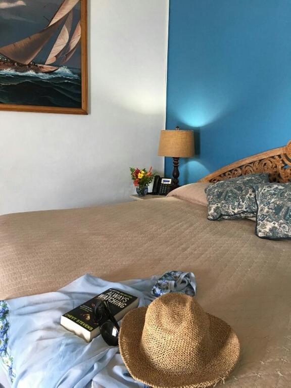 a hat and remote controls on a bed at Paradise Beach Hotel in Kingstown