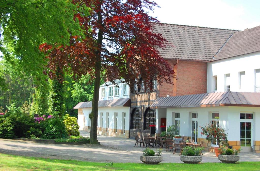 NeuenkirchenにあるLandidyll Wilminks Parkhotelの公園内のテーブルと椅子のある建物