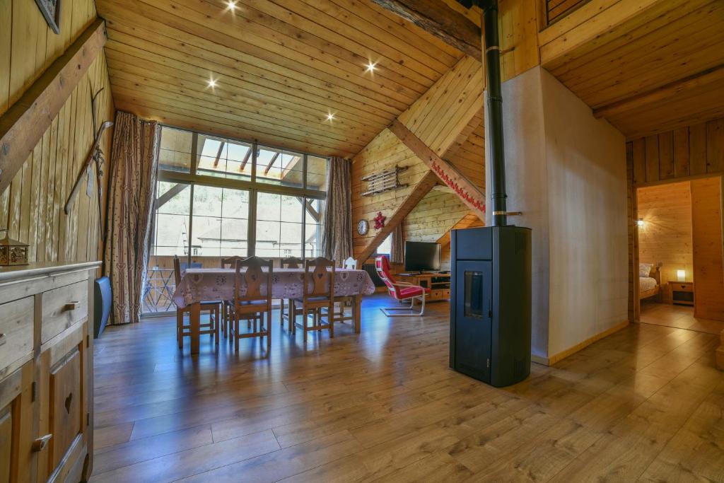 a large living room with a table and chairs at Appartement Le Chalet in Ornans