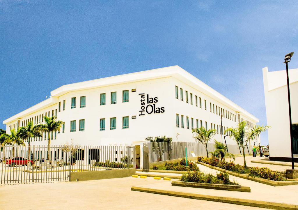 um edifício branco com uma cerca em frente em Hotel Las Olas Mamonal em Cartagena de Indias