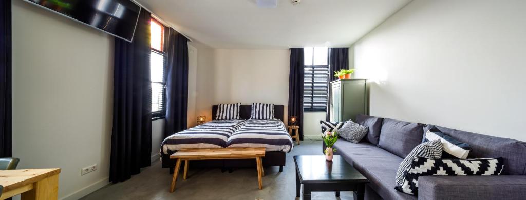 een woonkamer met een bank en een bed bij Bij Jans in Hilvarenbeek