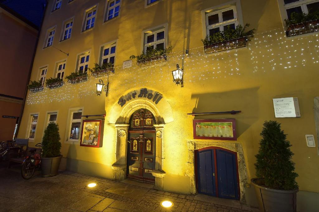 een verlicht gebouw met een deur op straat bij Gasthaus Zur Noll in Jena