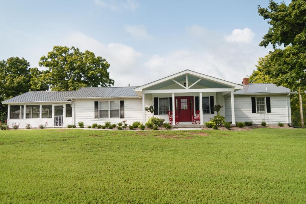 uma casa branca com uma porta vermelha e um quintal em Grandma's Cottage Sleeps 10 em Columbia