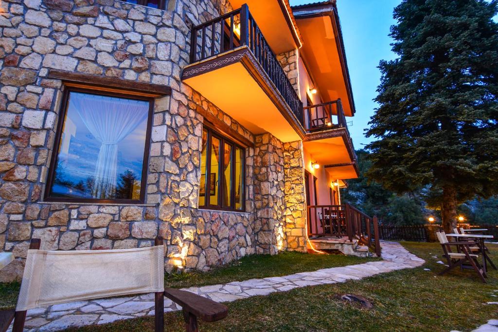 a stone house with a bench in front of it at Voreio Selas in Synikia Mesi Trikalon