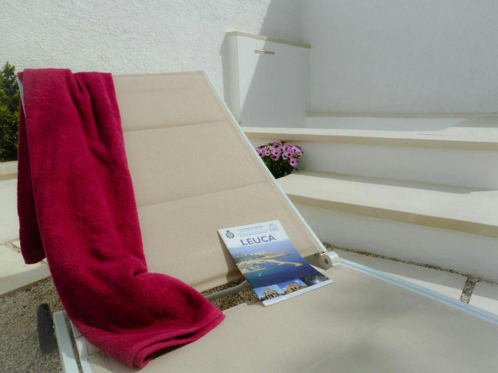 eine rote Socke auf einer Bank mit einem Buch in der Unterkunft Residence Leucasia in Santa Maria di Leuca