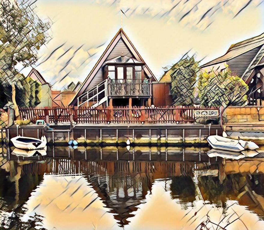 a painting of a house with a reflection in the water at Isleham River Lodge in Isleham