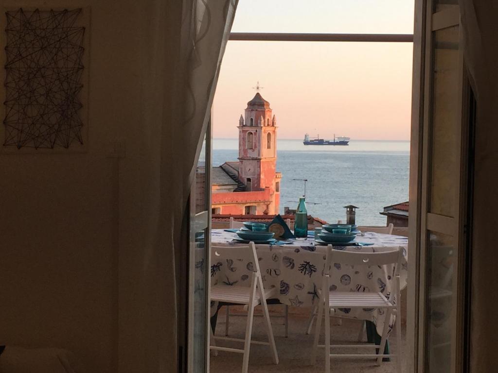 una mesa con vistas al océano y una torre del reloj en Amazing Apartment, en Tellaro