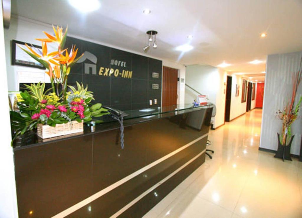 a lobby with a reception desk with flowers on it at Hotel Expo Inn Embajada in Bogotá