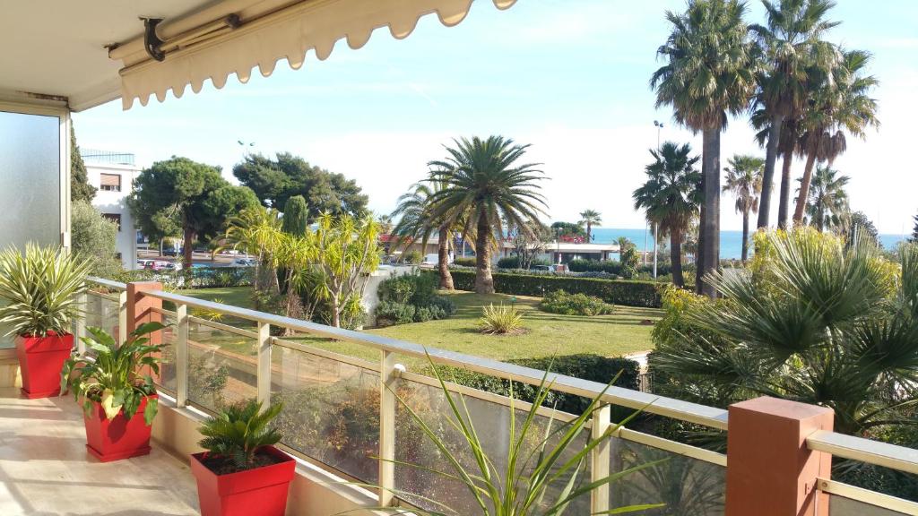 d'un balcon avec des palmiers et une vue sur l'océan. dans l'établissement Roc et Galets, à Saint-Laurent-du-Var