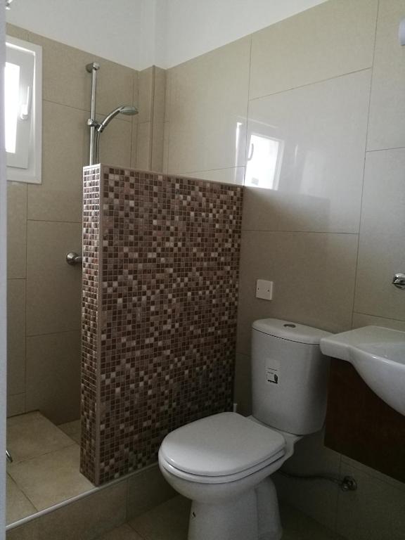 a bathroom with a toilet and a sink at Georgia Hotel Apartments in Protaras