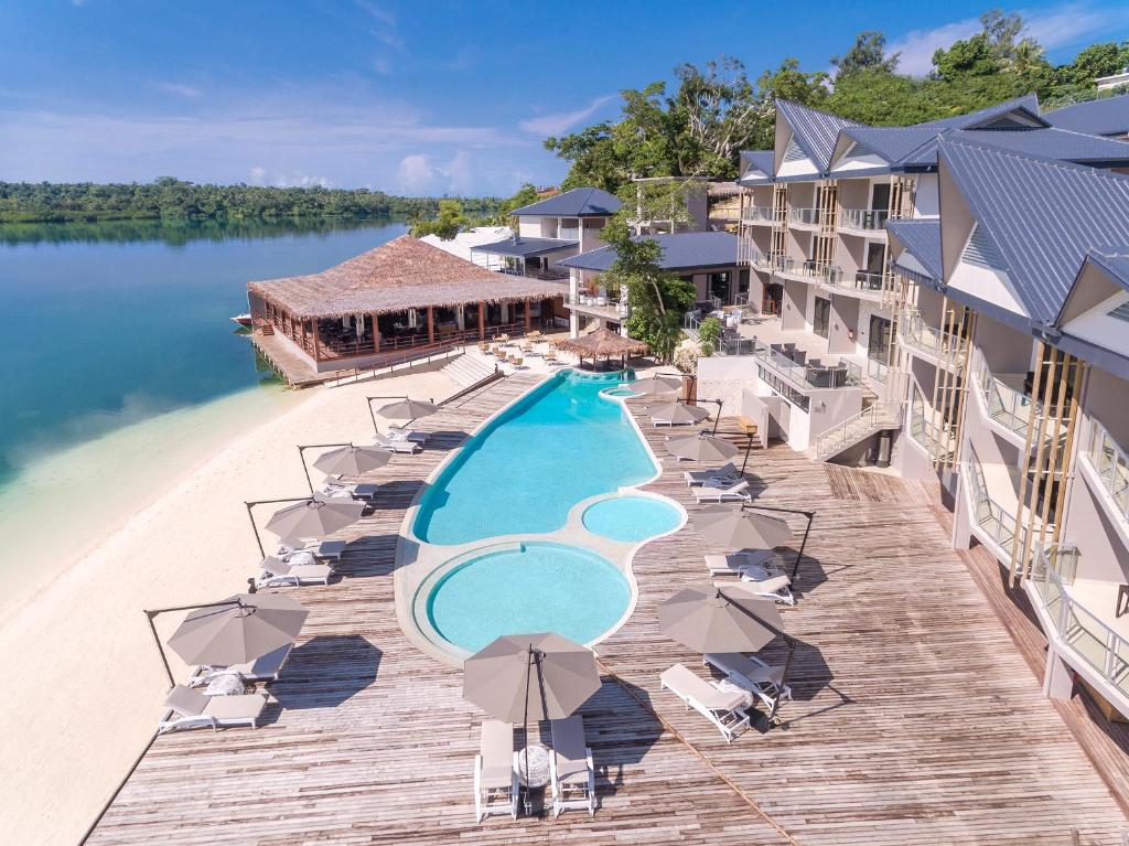 an aerial view of a resort with a pool and chairs at Ramada Resort by Wyndham Port Vila in Port Vila