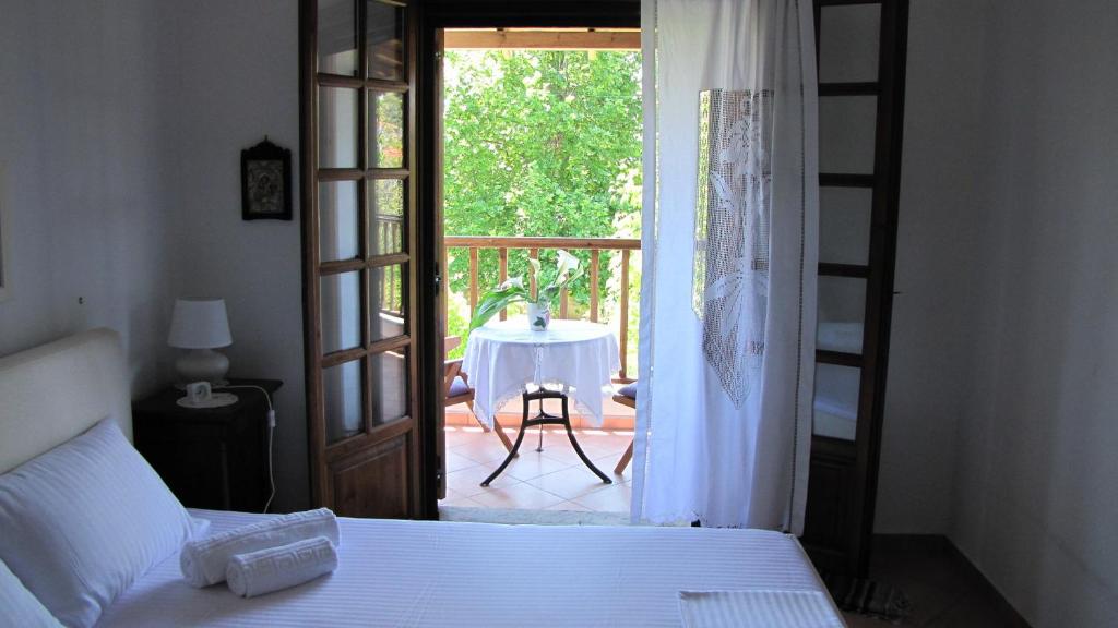 sypialnia z łóżkiem i drzwiami prowadzącymi na patio w obiekcie EL Villa Pelion w mieście Chorto