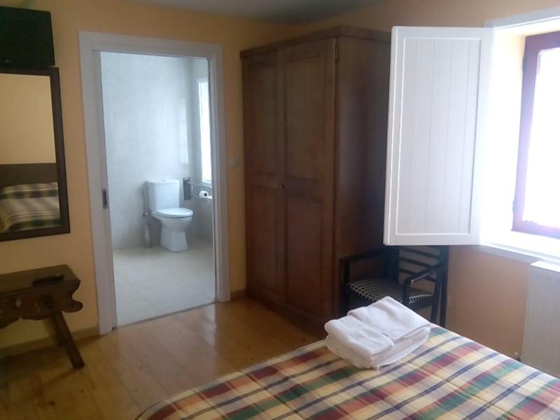 a bedroom with a bed and a bathroom with a toilet at Hotel Las Grandas in Vistalegre