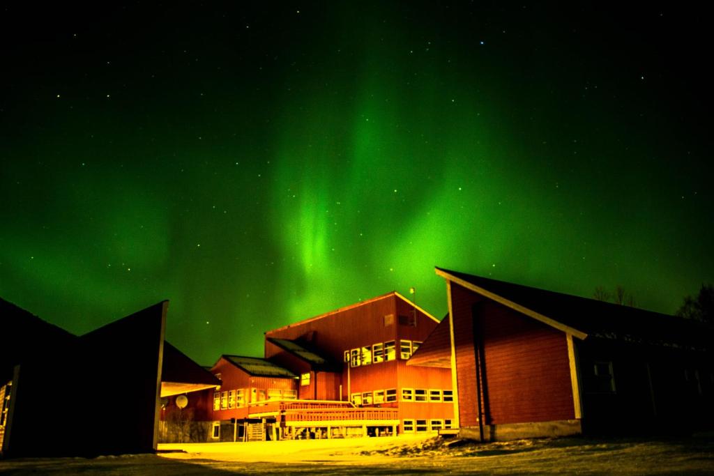 een gebouw met het noorderlicht in de lucht bij Tysfjord Hotel in Storjord I Tysfjord