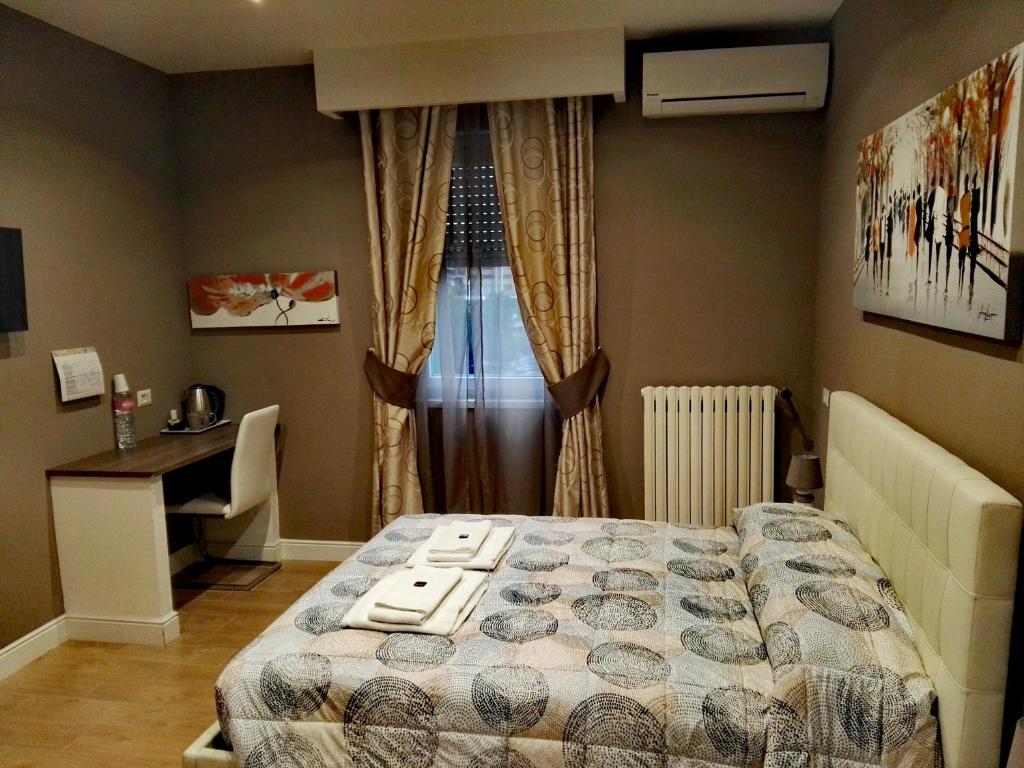 - une chambre avec un lit, un bureau et une fenêtre dans l'établissement Tollì rooms, à Rome