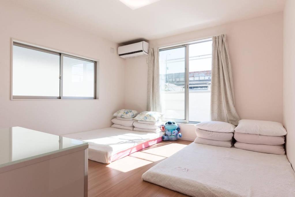 a living room with two beds and a window at Hinode House in Funabashi