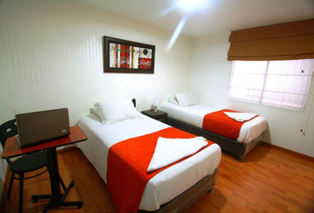 Postel nebo postele na pokoji v ubytování Hotel Expo Inn Embajada