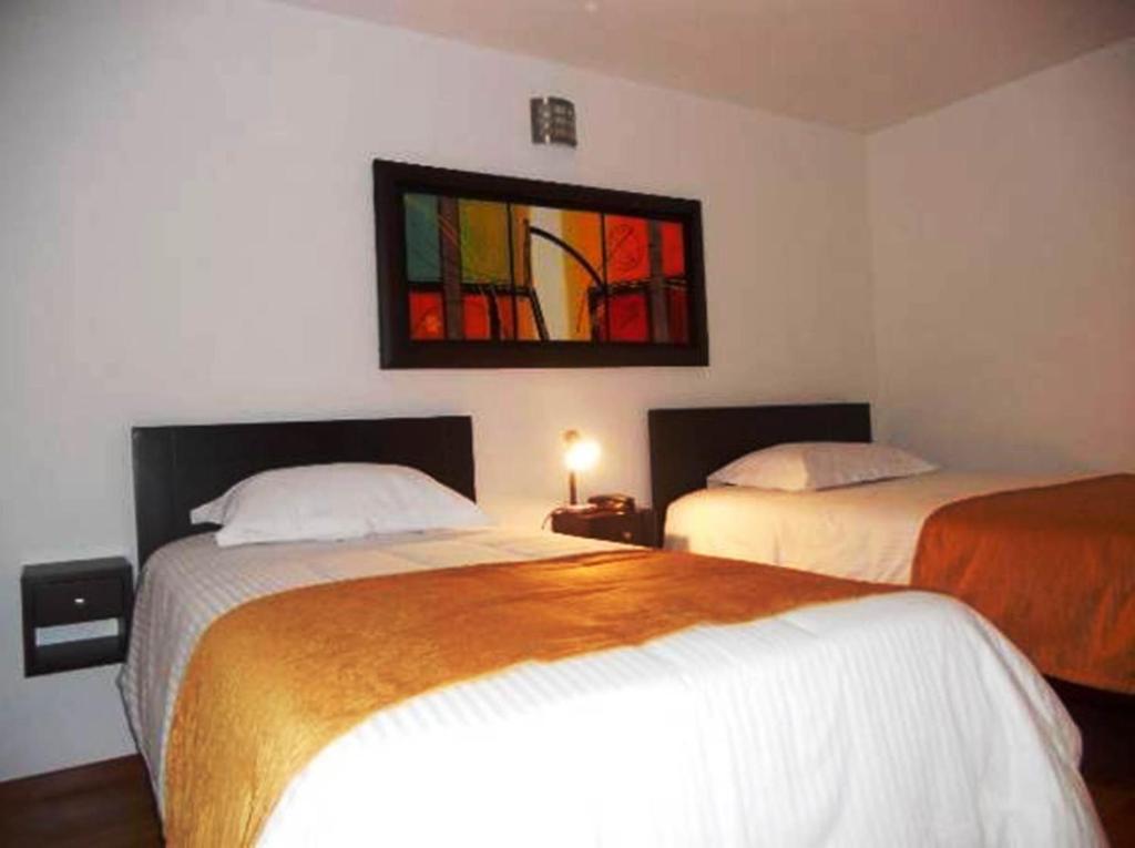 Postel nebo postele na pokoji v ubytování Hotel Expo Inn Embajada