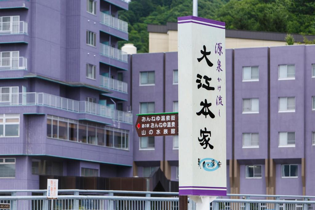 una señal frente a un edificio con señales asiáticas en Oehonke, en Kitami