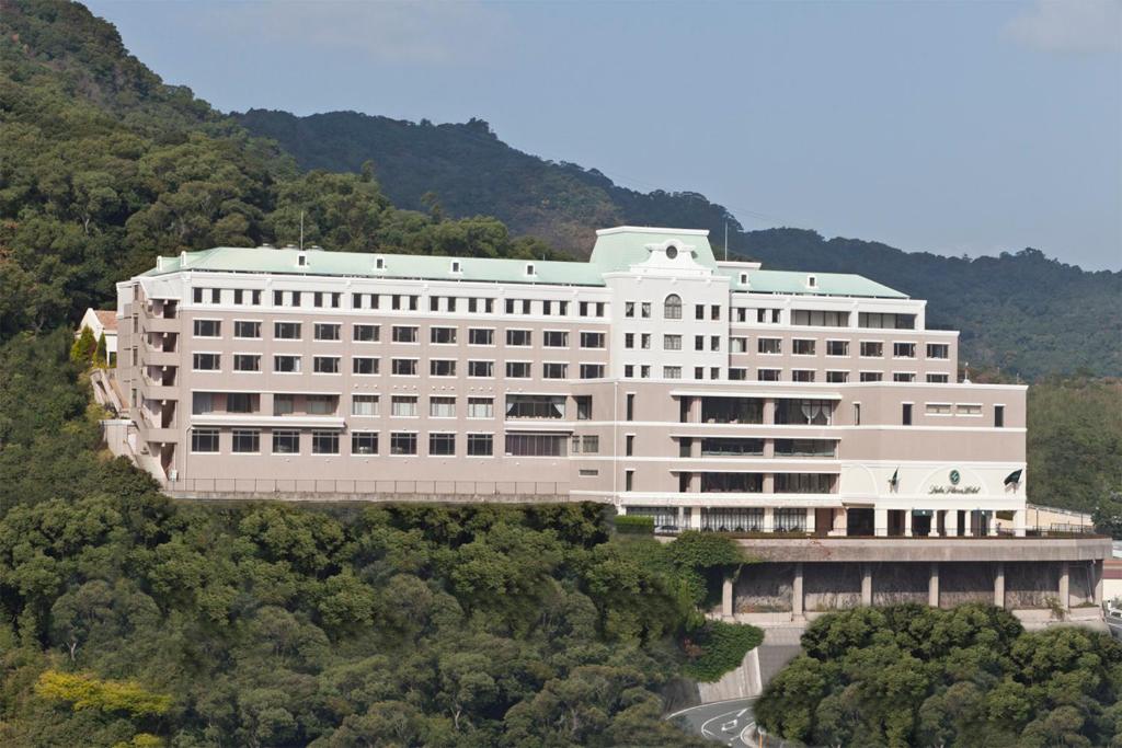 a large white building in the middle of a forest at Luke Plaza Hotel in Nagasaki