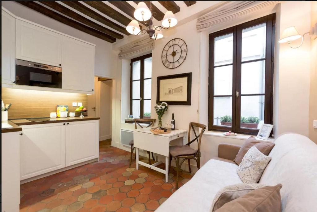 una cucina e un soggiorno con divano e tavolo di Le Voyage En Isle a Parigi