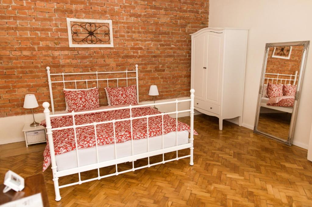 クルジュ・ナポカにあるOld City Apartments Eroilor - ULTRACENTRAL & FREE PARKINGの白いベッドとレンガの壁が備わるベッドルーム1室が備わります。