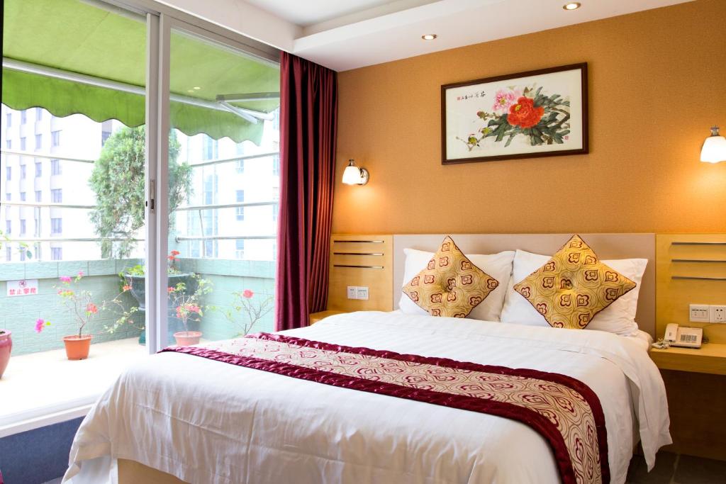 a bedroom with a large bed and a window at Guang Dong Hotel in Guangzhou
