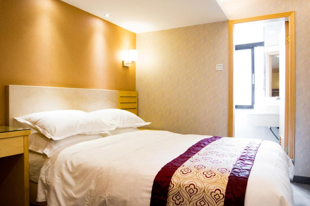 Postel nebo postele na pokoji v ubytování Guang Dong Hotel