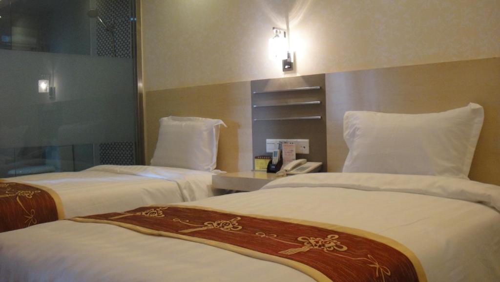 Postel nebo postele na pokoji v ubytování Guang Dong Hotel