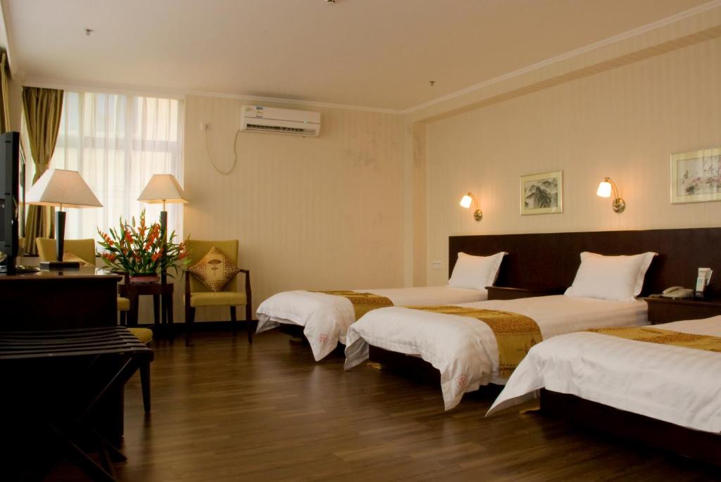 Postel nebo postele na pokoji v ubytování Guang Dong Hotel