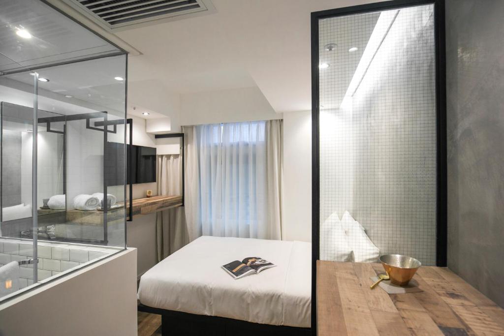 una camera da letto con un letto e una parete di vetro di Hotel Hart a Hong Kong
