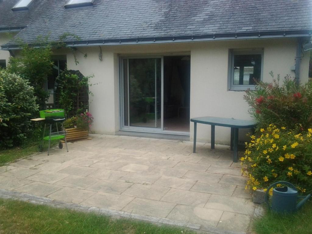 a patio with a blue table in front of a house at Jervl in Piriac-sur-Mer