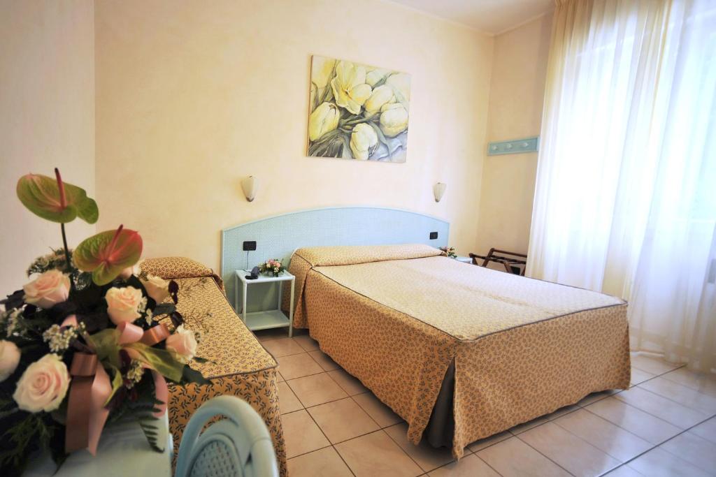 a bedroom with a bed and a table with flowers at Hotel Riviera Blu in Tirrenia