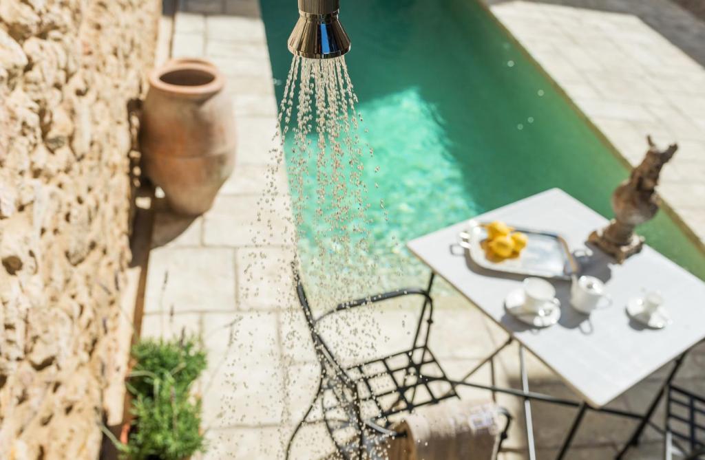 einen Tisch mit einem Teller Essen auf dem Tisch neben einem Pool in der Unterkunft Hotel Casa Peya - Adults Only in Palafrugell