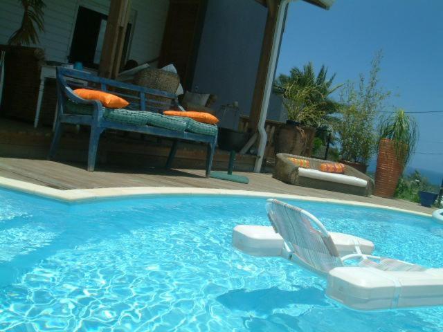 una piscina con 2 sillas de jardín y una silla. en La Buddha Case, en Étang-Salé